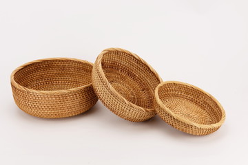 Three woven bamboo baskets against a white background.