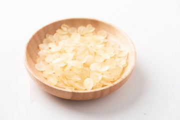 Fresh peach gum in a wooden bowl against a white background