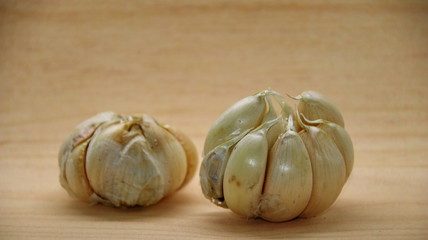 Unfocused, Blurry selective focus image, Garlic cloves on rustic in wooden table. Fresh peeled garlics and bulbs.