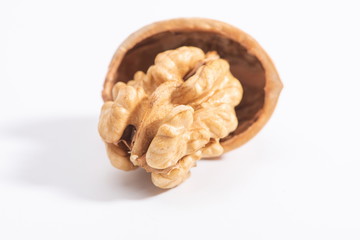 The walnuts poke open the shell to reveal the kernels in a white background