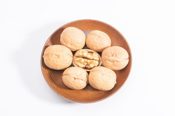 Fototapeta na wymiar A few walnuts in a wooden bowl, isolated in a white background