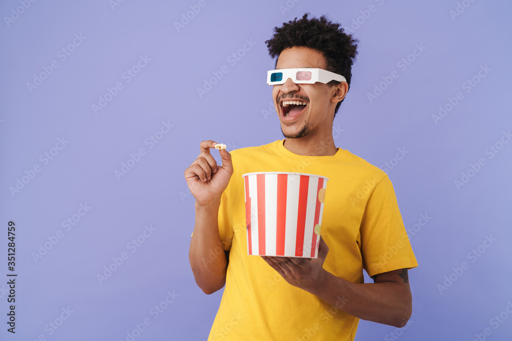 Sticker Photo of african american man watching movie and eating popcorn