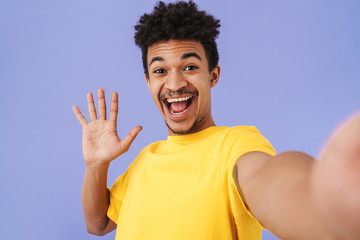 Fototapeta na wymiar Photo of african american man taking selfie photo and waving hand