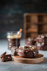 Chocolate donuts with chocolate glaze, nuts and coffee. National Donut Day. Homemade baking.