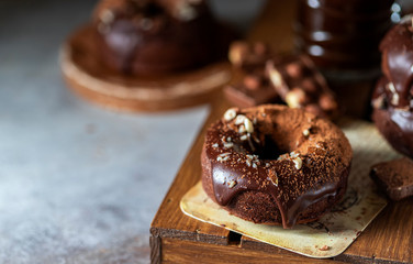 Chocolate donuts with chocolate glaze, nuts and coffee. National Donut Day. Homemade baking.