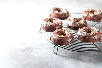 Chocolate donuts on a light concrete background. National Donut Day. Homemade baking.