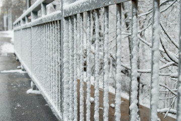 Street fence covered with snow on a winter's day.