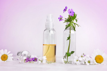 front view of essential oil and freshness  flowers in bottle on  a table