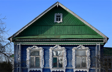 Small blue-green house with beautiful carved windows in the countryside 