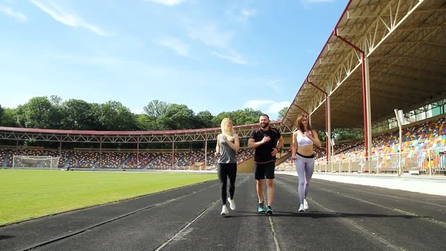 Young athletes run a distance on the treadmill through the stadium. Sports training and competition athletes