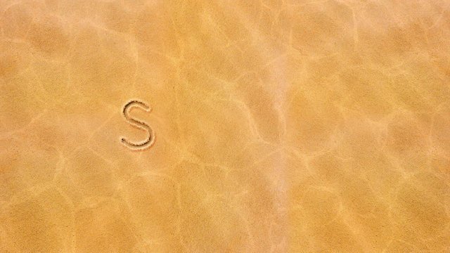 Handwritten animated text in the sand, the day of the week is Sunday.
