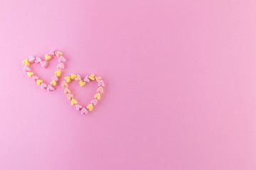 Minimalistic pink background with small hearts for a love card. Copy space.