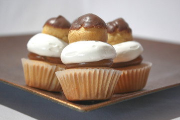 small cupcakes with meringue and chocolate profiteroles