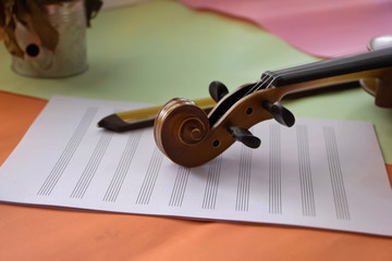 Fototapeta na wymiar Closeup Scroll of violin put on blank note sheet,blurry light around