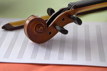 Closeup Scroll of violin put on blank note sheet,blurry light around