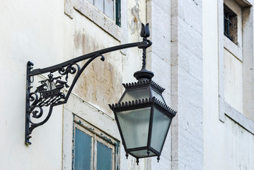 Fototapeta na wymiar wrought iron lantern with the city's coat of arms: a caravel and two crows in Lisbon