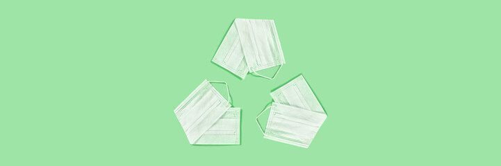 Medicine green background. The universal recycling symbol made from the medical masks on green background.