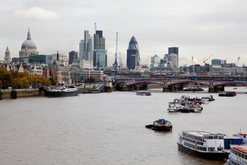 the River Thames looking east towards St.Pauls cathedral and the city with a boats in the foreground 