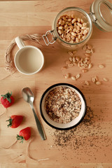 desayuno con fibra , avena, musli, fresas sobre mesa de madera clara
