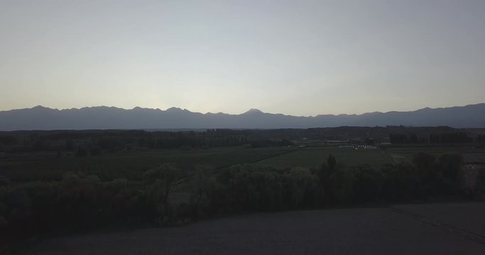 Ungraded, Ascending aerial flight with backtracking view to reveal mountain range of Cordillera de los Andes during golden hour. Drone, 4K. 
Valle de Uco, Tupungato, Mendoza, Patagonia, Argentina