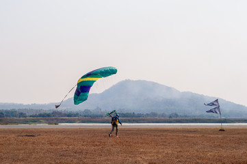 Parachutist landing beside runways on small airfield