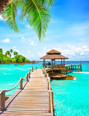Sea with pier under blue cloudy sky