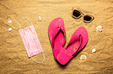 Surgical face mask, pink flip flops and sunglasses - covid-19 vacation