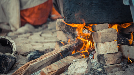 Fire burning under a black cauldron on top