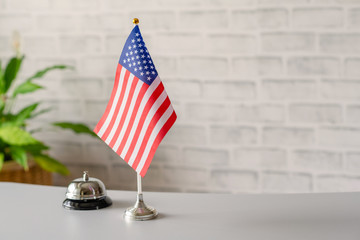 Silver vintage bell with national flag of United State on reception desk with copy space. Hotel service. Travel, tourism. America, USA, Concept.