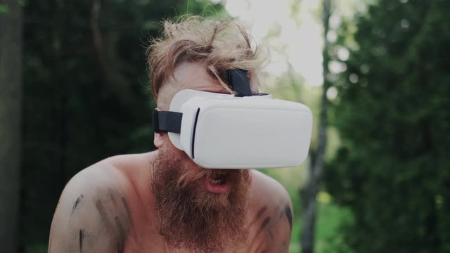 Closeup portrait. Facial Expression of Shocked, Stunned Caveman after Using VR Goggles. Excited Human Reaction. Cyberspace with Full Presence. Wireless Modern Futuristic Gadget in Simple Life.
