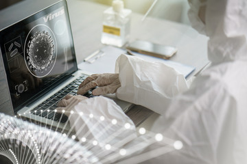 Woman in protective hazmat suit worker  in laboratory computer analyzing in laboratory. to stop spreading coronavirus or COVID-19.