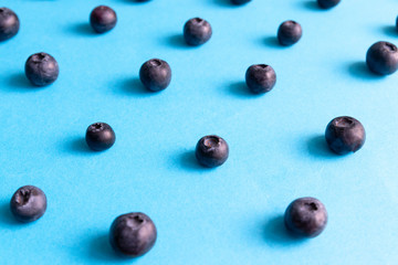 Fresh ripe blueberry berries pattern on a blue background