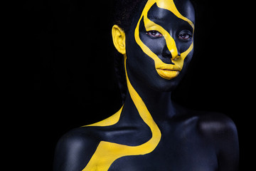 Woman with black body paint. Cheerful young african girl with art bodypaint. An amazing model with...