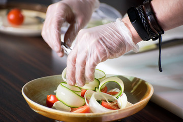 Cooking a salad, a salad of fresh vegetables with olive oil.