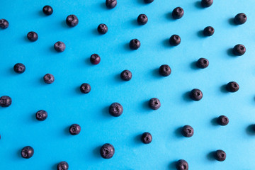 Pattern of delicious fresh blueberries on blue background