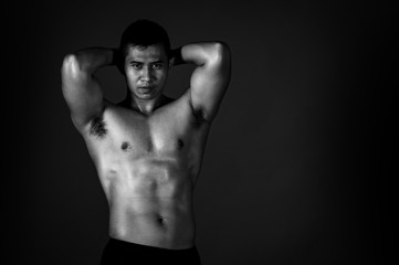 Fototapeta na wymiar A strong Asian man raised his arms to show his strong and beautiful muscles from exercise