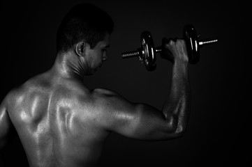 The strong Asian man lifted his dumbbell regularly to keep his muscles strong and beautiful