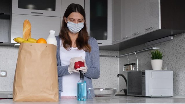 Disinfection of products. World pandemic. Spray antiseptic. Pandemic coronavirus. Woman disinfects products from the store using a mask and spray antiseptic