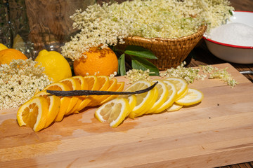 On a cutting board lie a sliced organic lemon and organic orange and a vanilla pod for the...