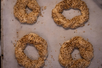 Top view of home made Turkish bagel or simit doughs over white kitchen table. Cooking, food, healthy eating and home concept.