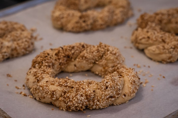 Top view of home made Turkish bagel or simit doughs over white kitchen table. Cooking, food, healthy eating and home concept.