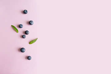 Fresh blueberries berry and leaves on pink background. Proper Diet Healthy Eating. Minimal composition