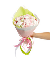 Stylish bouquet of marshmallows in a female hand on a white background