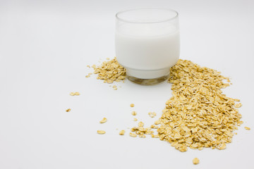 fresh organic coconut milk in the glass and oatmeal muesli placed on white studio background....