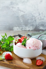 Homemade Organic Strawberry Ice Cream. Strawberry ice cream balls with mint leafon a light stone or slate table. Copy space.