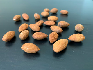 Almonds on the black table. Healthy and satisfying snack. The concept of proper nutrition.
