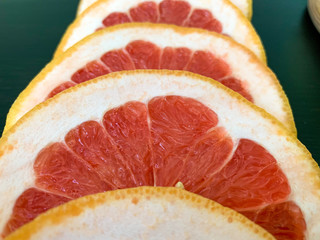 Sliced grapefruit in circles on a black table. Proper nutrition, vitamins, healthy snacks. 