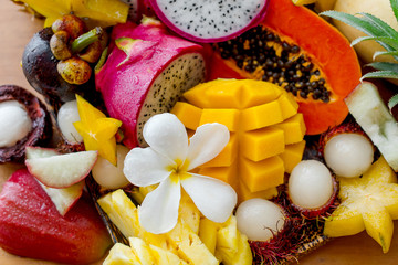 Fototapeta na wymiar Juicy ripe tropical Thai fruits on a wooden dish.