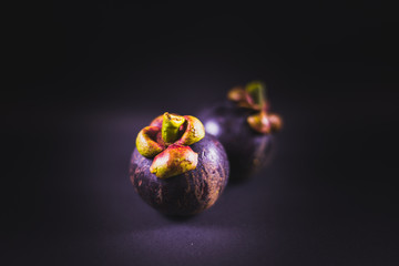 Ripe mangosteens in black background, Fresh mangosteens with dark background.