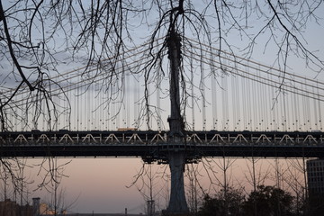 A winter sunset paints the sky behind the Brooklyn Bridge